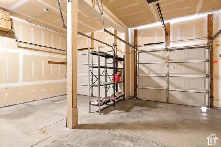 Spacious garage with two overhead doors and concrete flooring