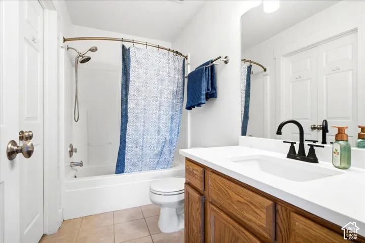 White vanity with wood-finish cabinetry, white countertop, and black faucet