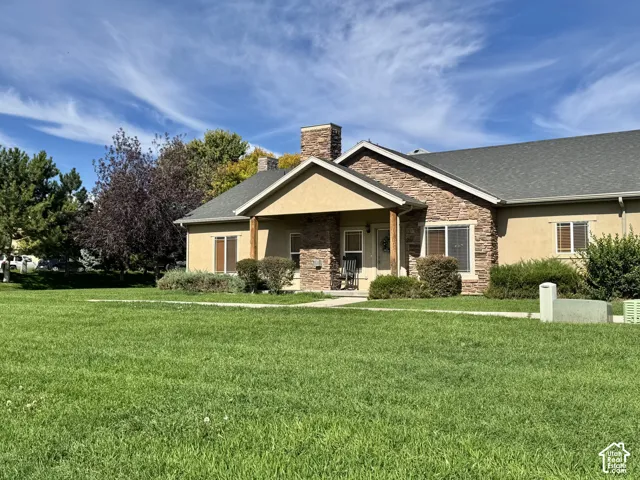 Exterior front entryway with covered porch facing the grass common area.