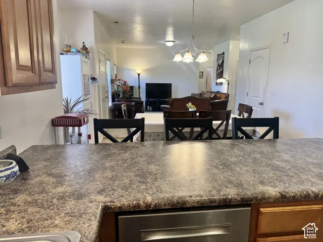 Kitchen & Living Area, view 1.  Dining area includes counter seating options, kitchen area for dining table & carpeted living area.