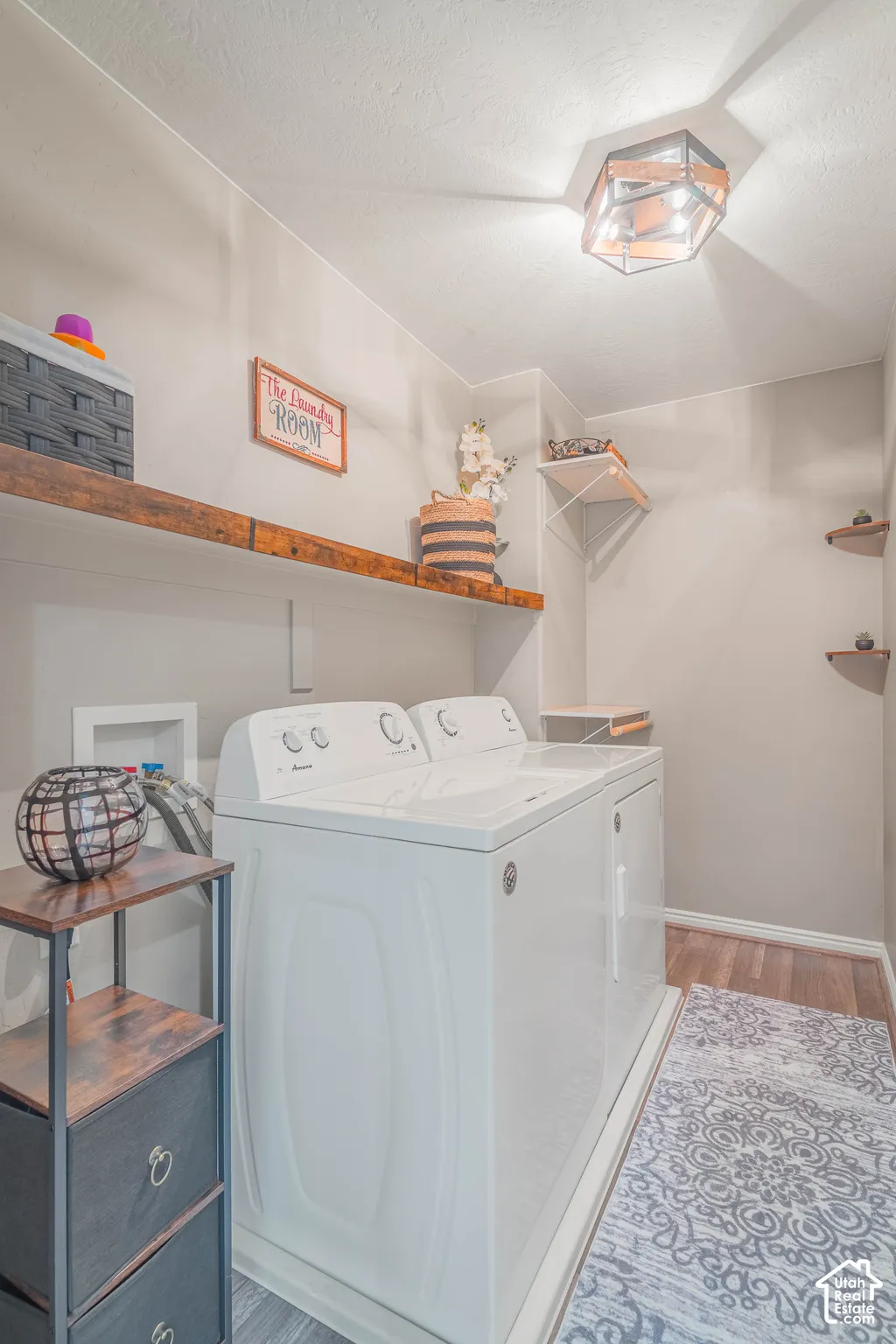 Dedicated laundry area featuring a flush mount light fixture, wood-finish flooring, and open shelving