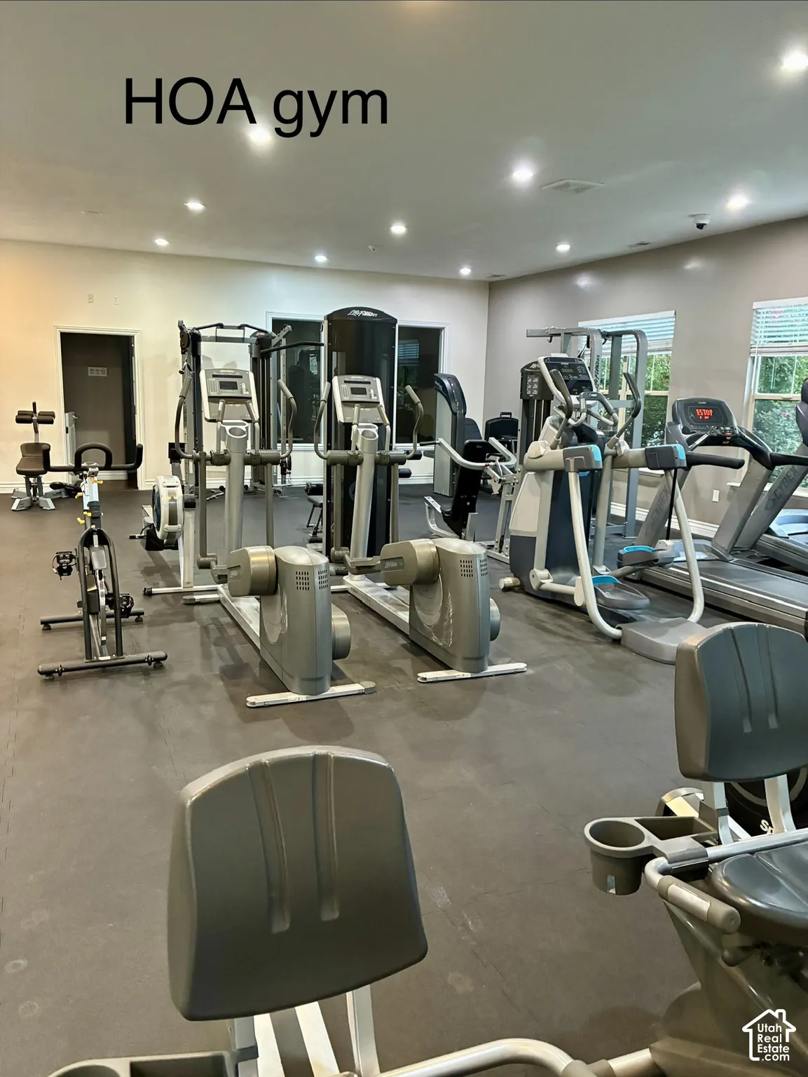 Fitness center featuring a variety of exercise equipment, recessed lighting, and wall-mounted blinds