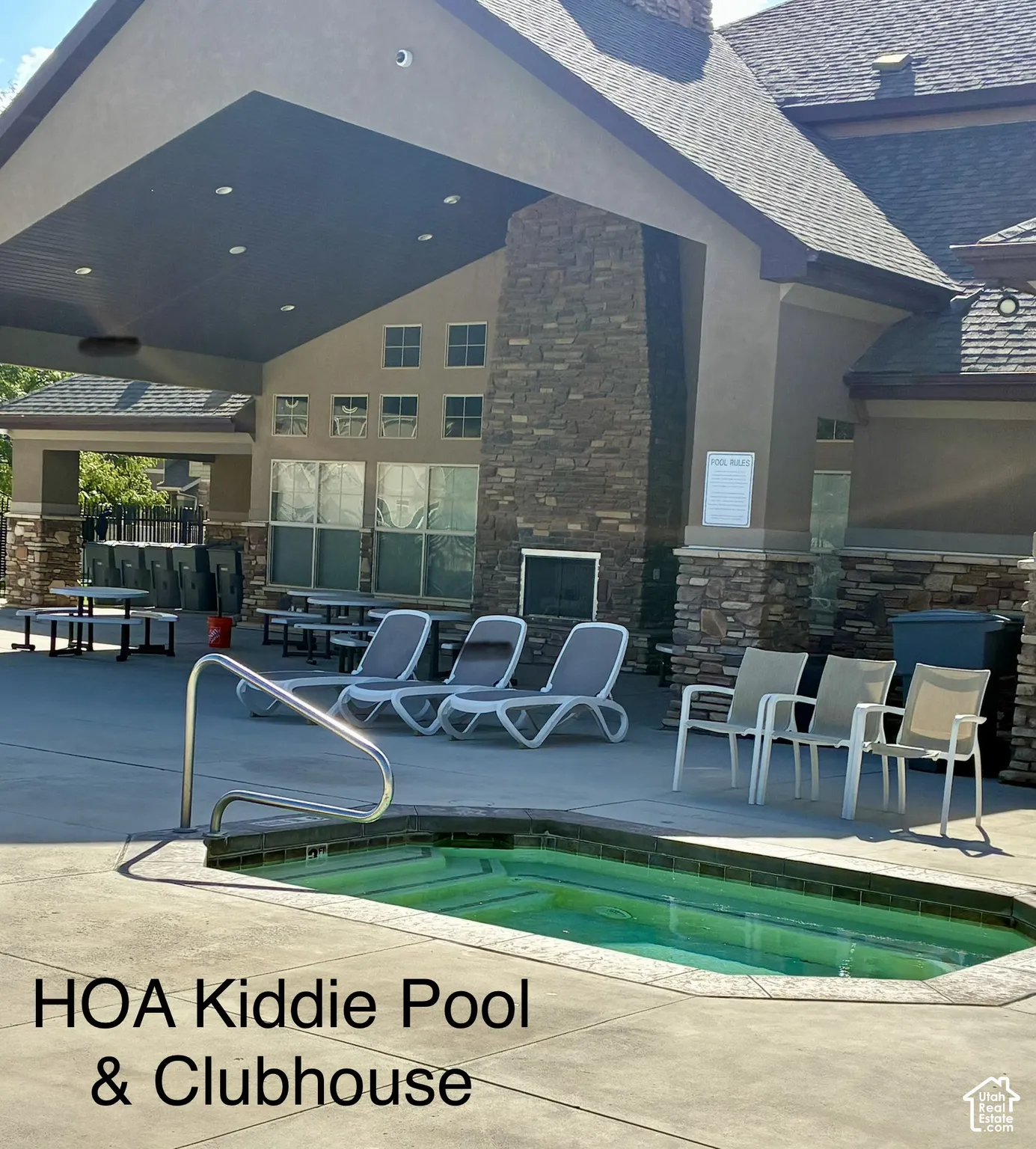Spacious clubhouse with stone-clad exterior, a covered patio area, and an integrated pool
