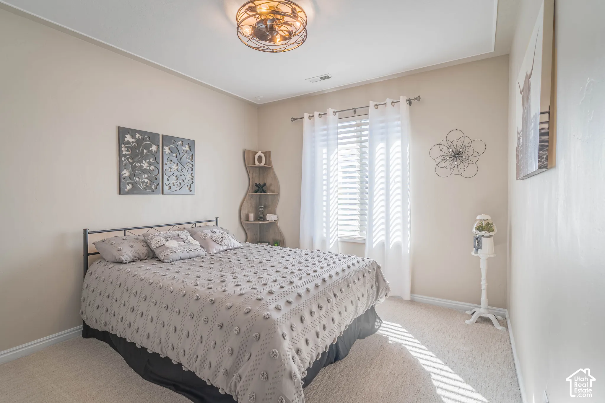 Recessed window with white blinds and sheer curtains, complemented by a decorative ceiling light fixture