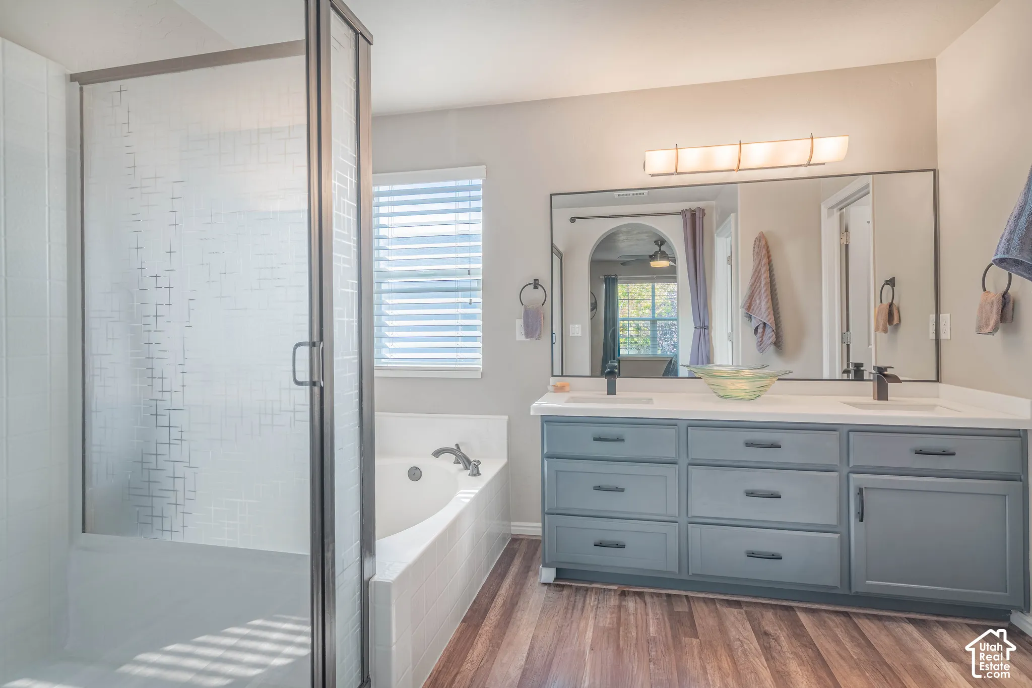 Dual vanity with gray cabinetry, white countertops, and matte black fixtures
