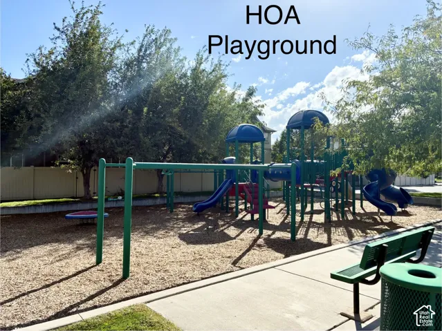 Community playground featuring multiple slides, climbing structures, and swings over wood chip surfacing