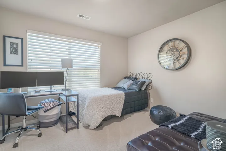 Carpeted room with a large window featuring horizontal blinds