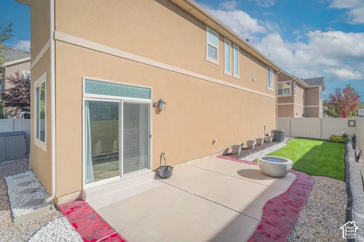 Patio area with concrete slab, gravel landscaping, and a manicured lawn