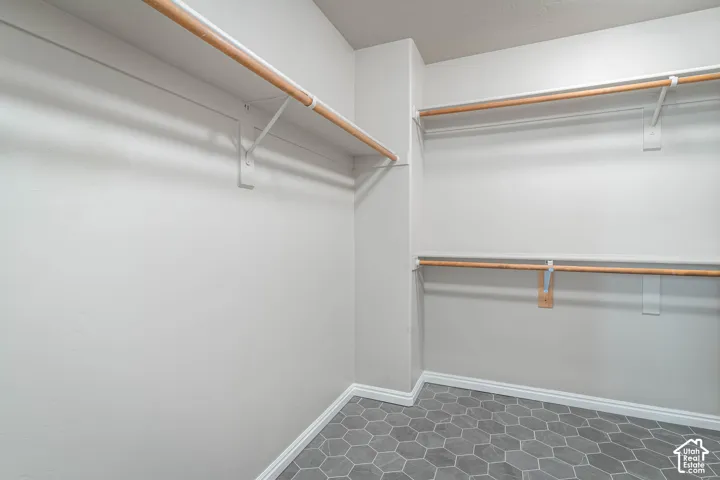 Hexagonal floor tiling, white walls, and built-in closet rods