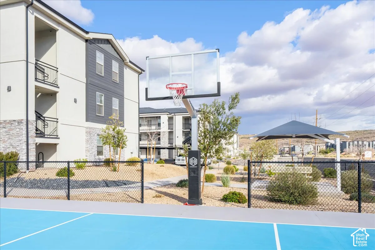 Community basketball court with a chain-link fence, a modern shade structure, and rock landscaping