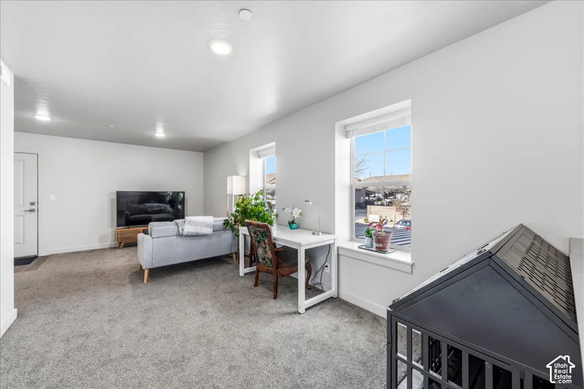 Recessed ceiling lighting, white interior door, light gray carpet, and white window trim