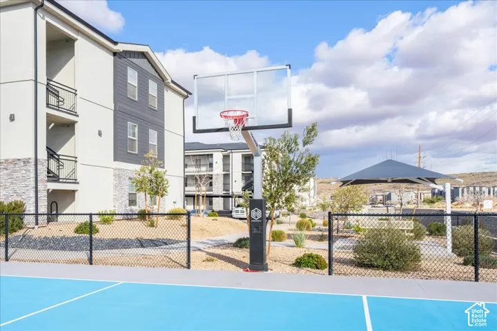 Community basketball court with a chain-link fence, a modern shade structure, and rock landscaping