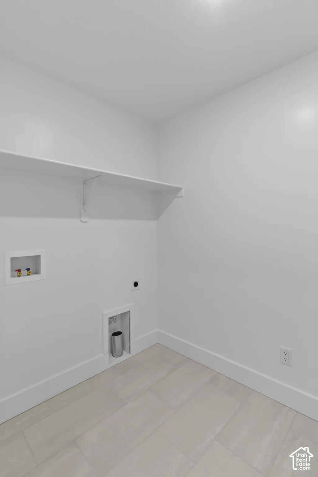 Light-toned plank tile flooring, crisp white walls, and a built-in wall shelf