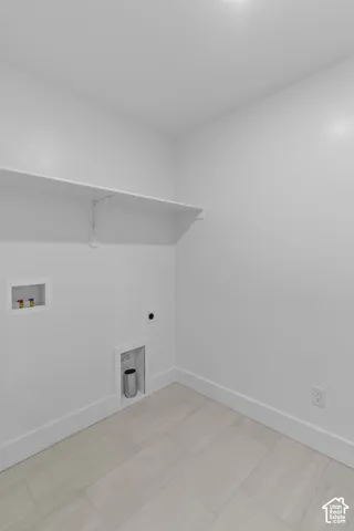 Light-toned plank tile flooring, crisp white walls, and a built-in wall shelf