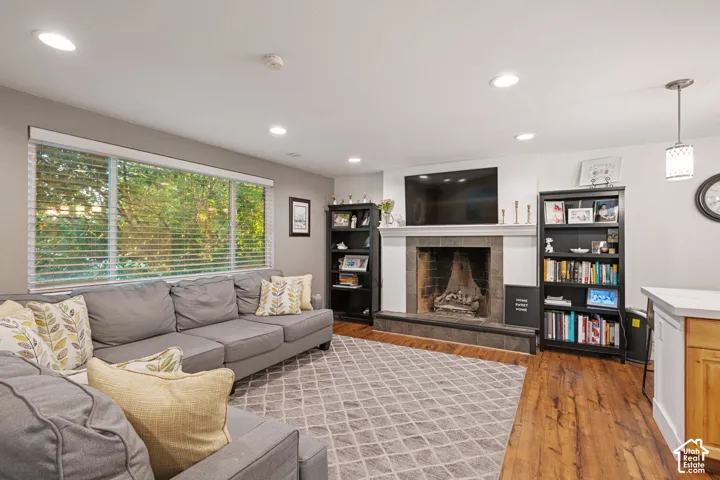 Recessed ceiling lighting, gas fireplace with mantel, and large windows