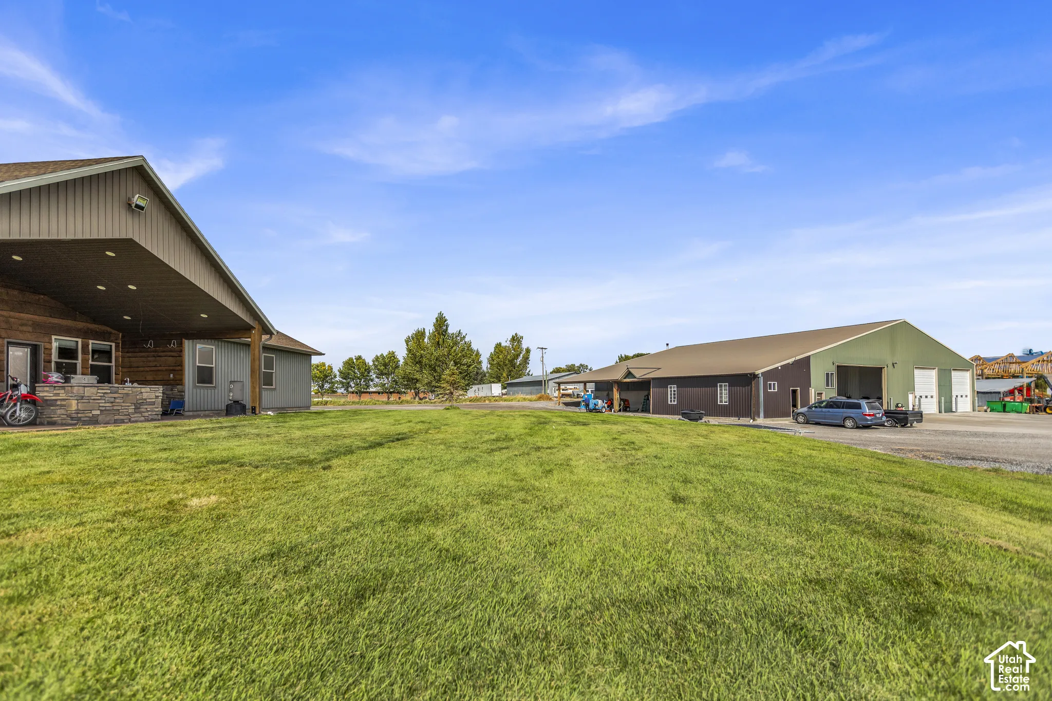 Expansive green space with an adjacent gravel parking area