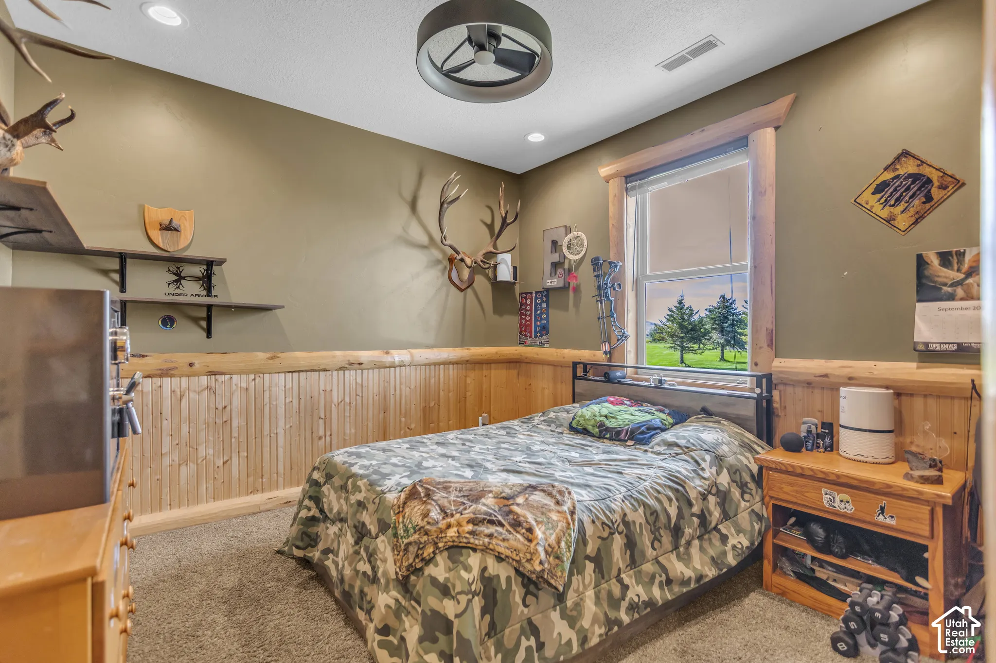 Recessed lighting, ceiling fan, wood paneling, wood window trim, and carpeted flooring