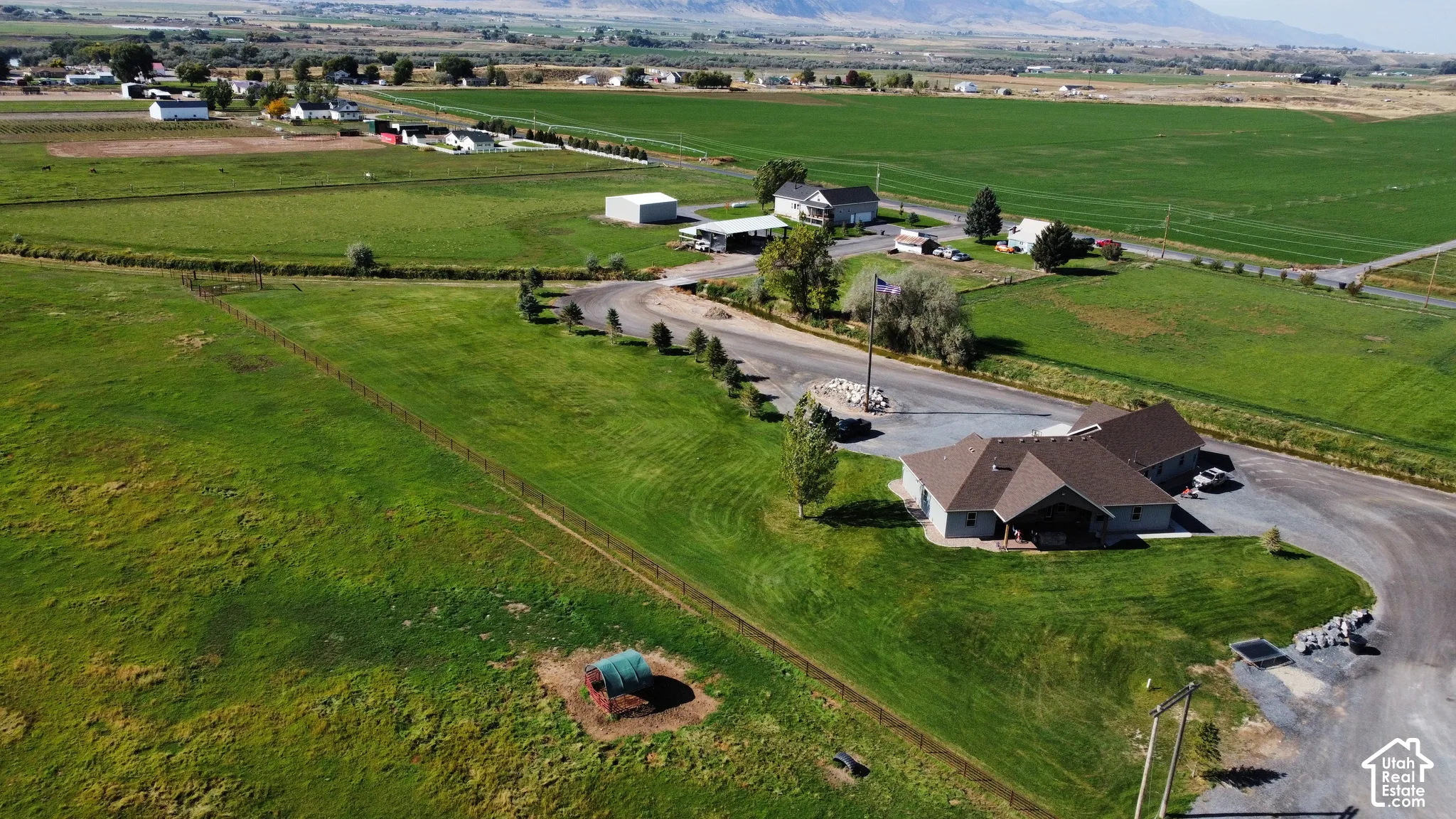 Expansive green fields, large property, and mountainous backdrop
