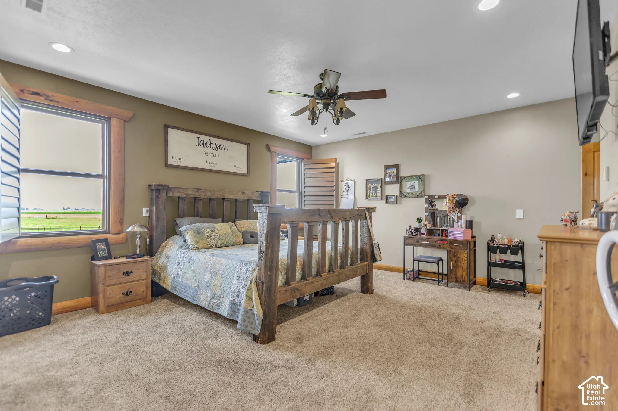 Carpeted room featuring a ceiling fan with light fixture, recessed lighting, and windows with plantation shutters