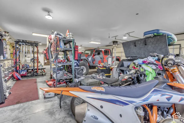 Concrete flooring, recessed lighting, fluorescent strip lighting, and a roll-up garage door