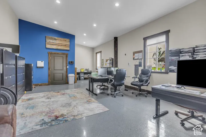 Spacious room with high vaulted ceilings, recessed lighting, and polished concrete flooring