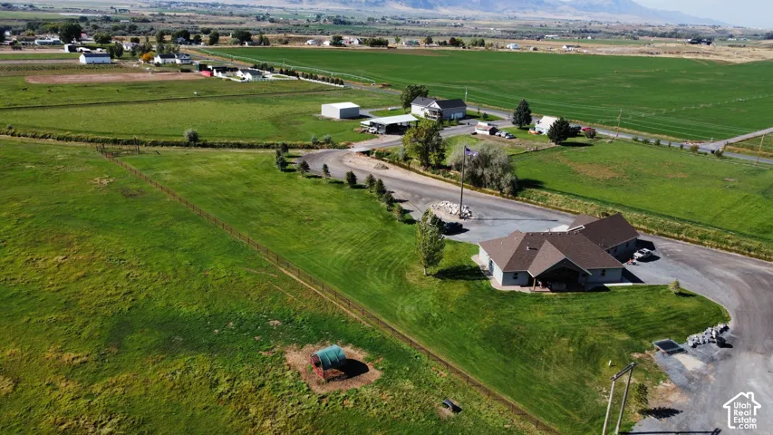 Expansive green fields, large property, and mountainous backdrop