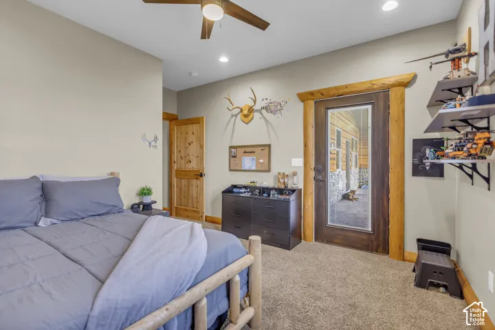 Carpeted room with a ceiling fan, recessed lighting, and a wood-frame bed
