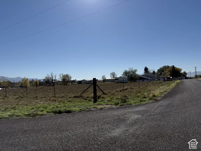 Expansive open lot with a wire fence and a gravel road