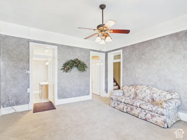 Carpeted flooring, ceiling fan with integrated lighting, white trim, and crown molding