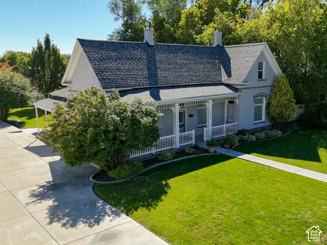 Gabled roofline with dark shingles, light gray exterior, and white trim