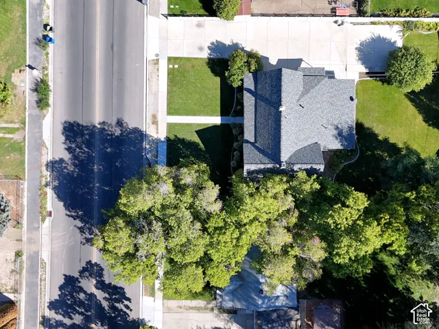 Gabled roofline, asphalt shingle roofing, concrete driveway, and manicured lawns