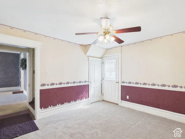 Wall-to-wall carpeting and a ceiling fan with integrated lighting
