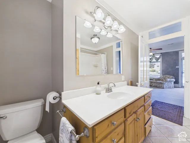 Vanity with wood-finish cabinetry, white countertop, and integrated sink