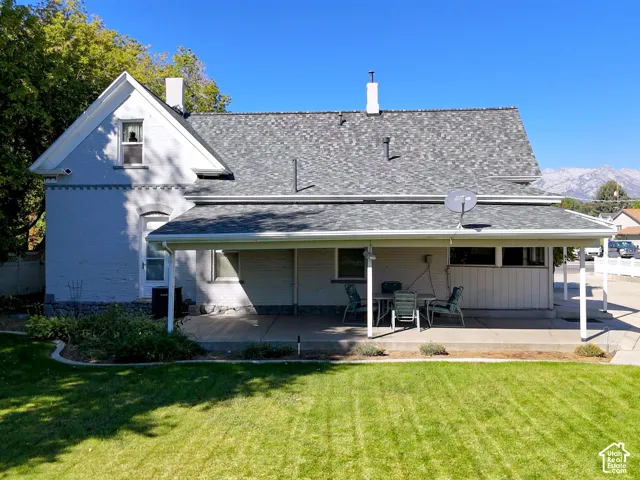 Brick exterior with a gabled roofline, covered patio, and a manicured lawn
