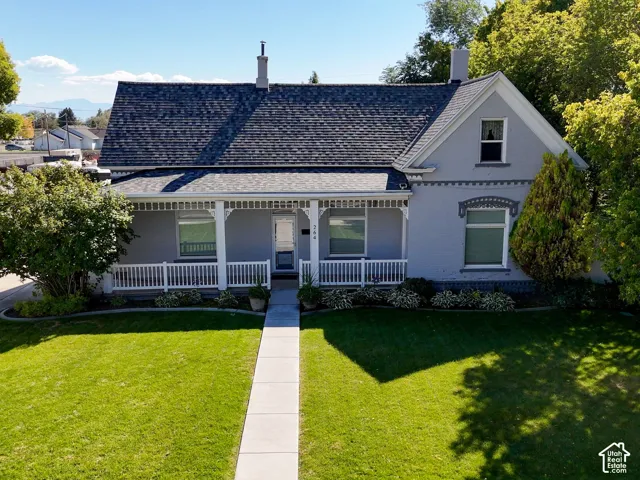 Front exterior with a covered porch, white railing, and gabled roofline
