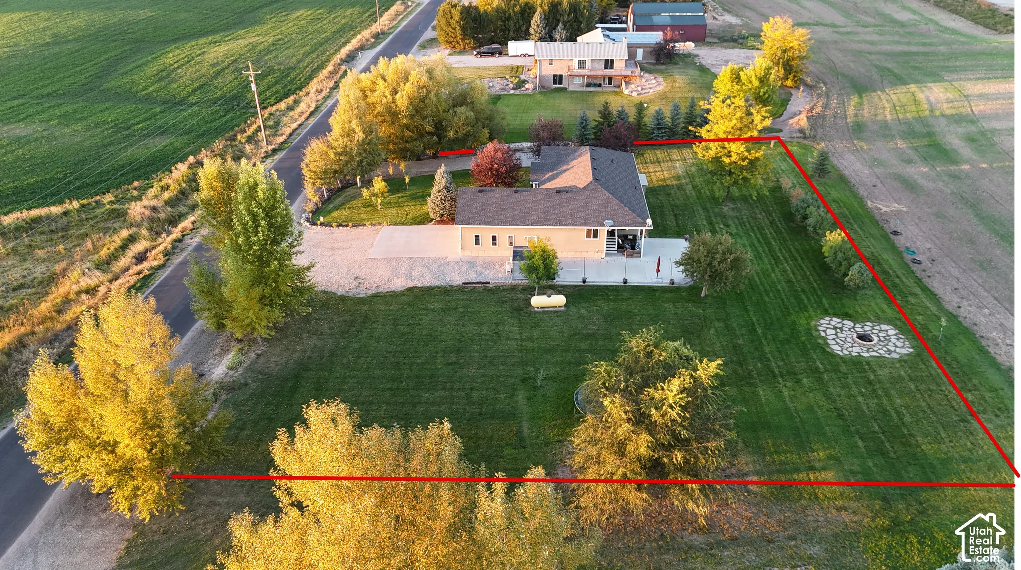 Expansive lawn area with a stone-lined fire pit