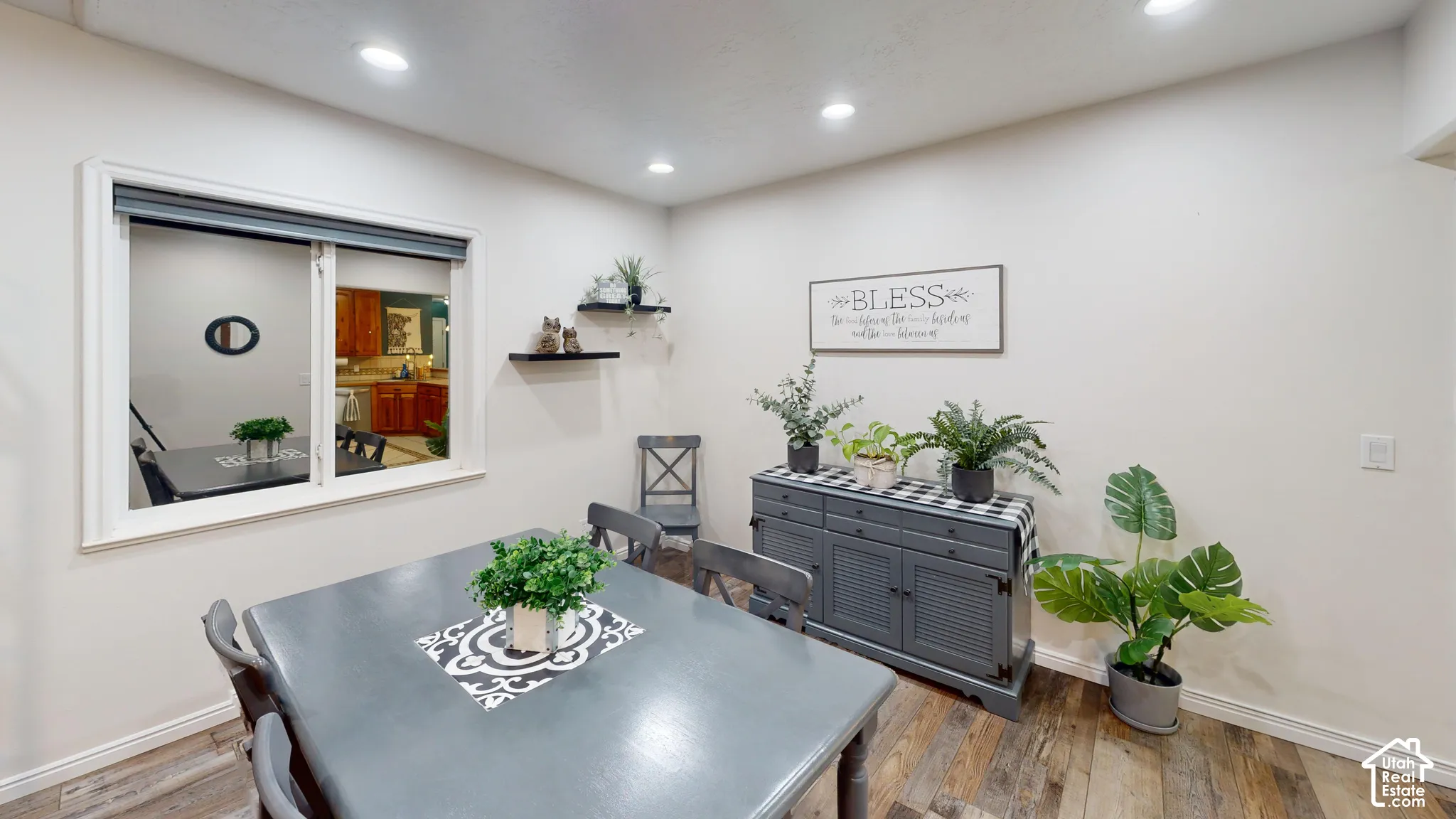 Recessed lighting, wood-finish flooring, white walls, and a built-in window with white trim