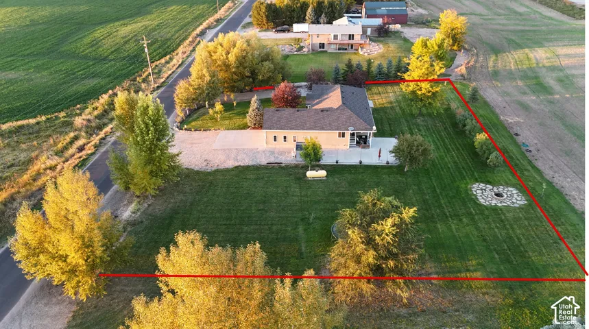 Expansive lawn area with a stone-lined fire pit