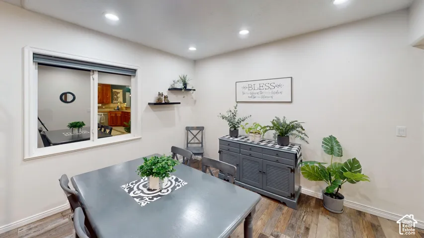 Recessed lighting, wood-finish flooring, white walls, and a built-in window with white trim