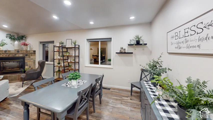 Wood-finish flooring throughout, recessed lighting, and a stone-surround fireplace with hearth