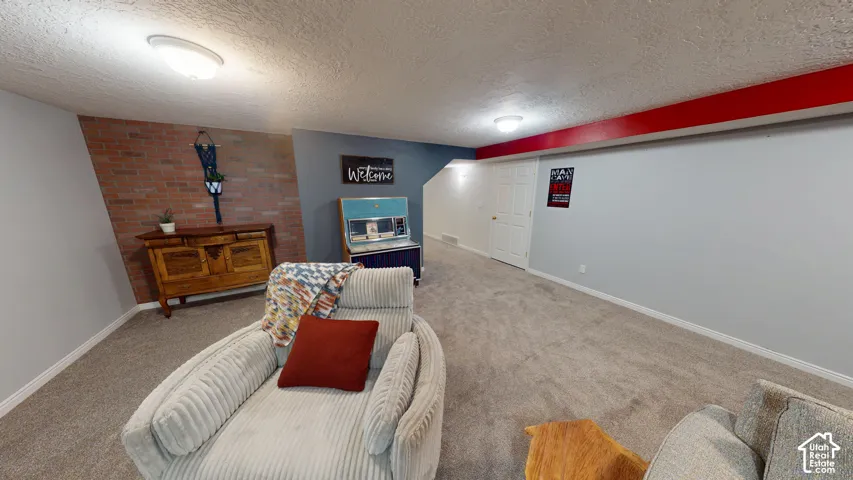 Carpeted flooring, recessed lighting, brick accent wall, and painted walls