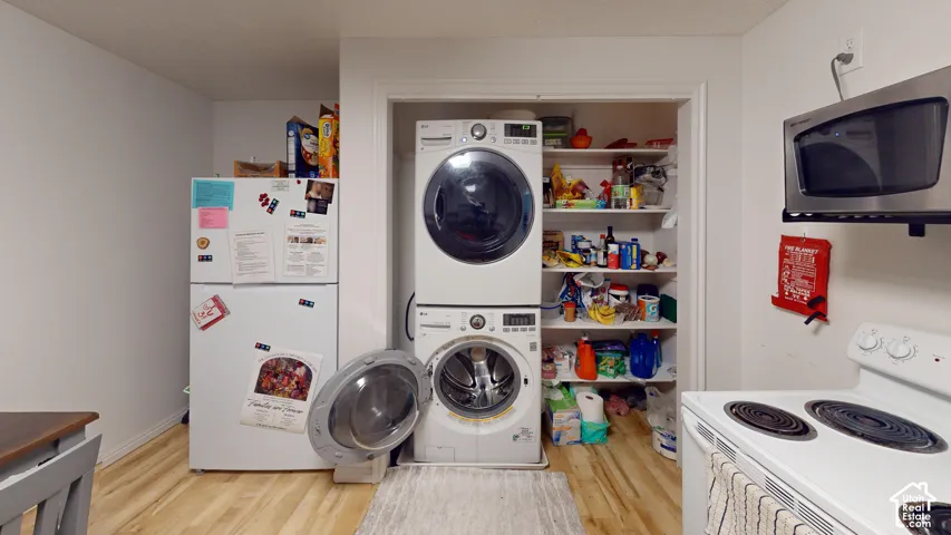Hardwood-finish flooring, built-in shelving, and stacked laundry appliances