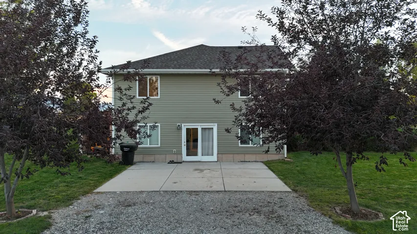 Two-story siding exterior with multiple windows, a rear patio, and a sliding glass door