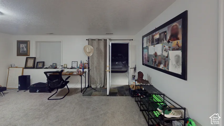 Carpeted room with white walls, a built-in shelf, and a window with trim