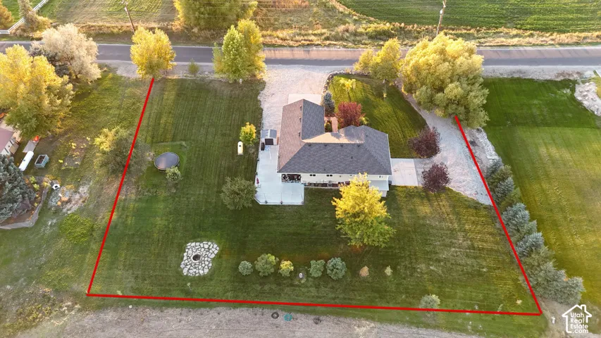 Expansive lot with a pitched roof residence, mature trees, and a paved driveway