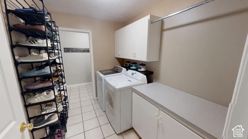 Laundry area featuring white cabinetry, a built-in countertop, and tile flooring