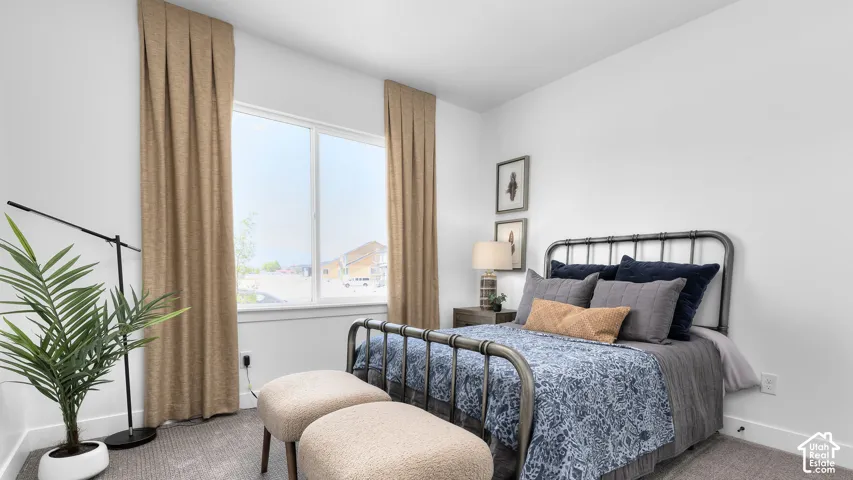 White walls with a large window, complemented by pleated drapes