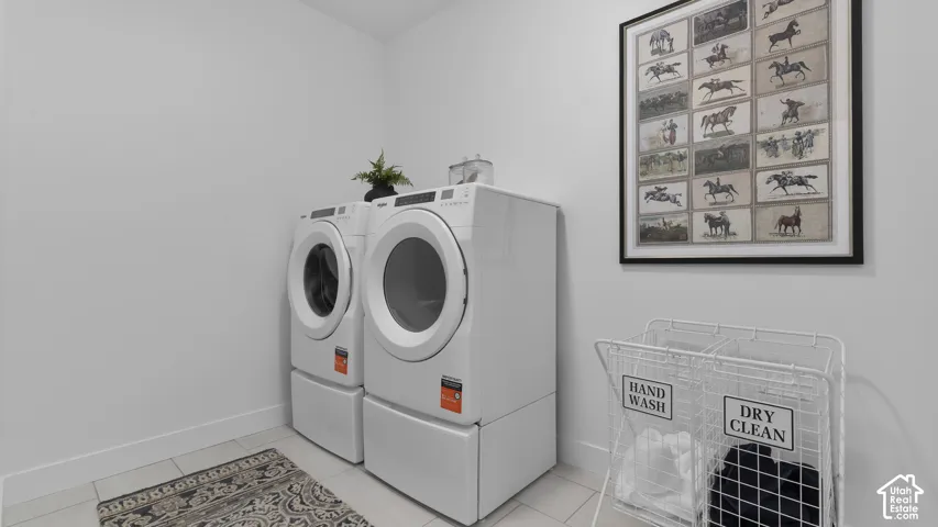 White wall paint, light-toned tile flooring, and integrated laundry appliances