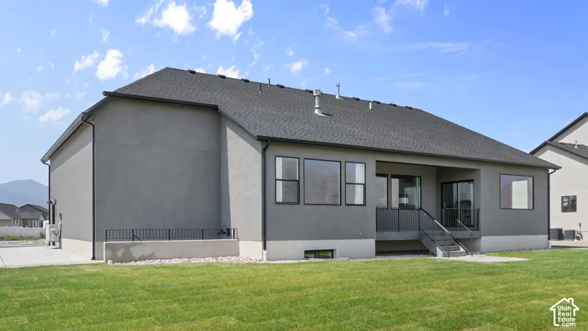 Gray stucco exterior with multiple windows, a covered patio, and a sliding glass door