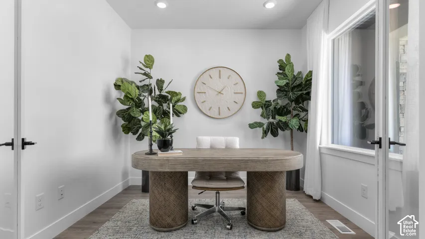 Recessed ceiling lighting, wood-finish flooring, white walls, and a window with white trim